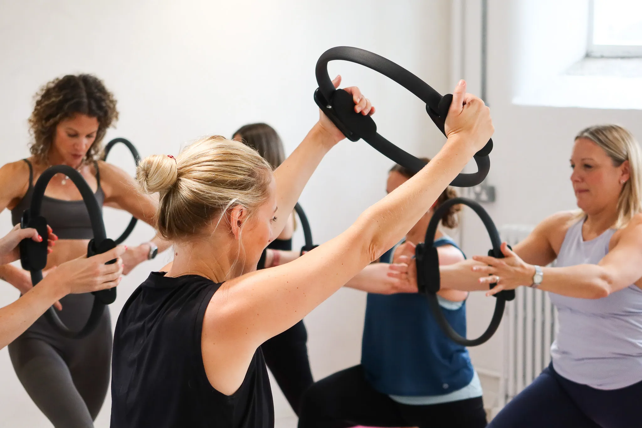 Group fitness class working with pilates rings